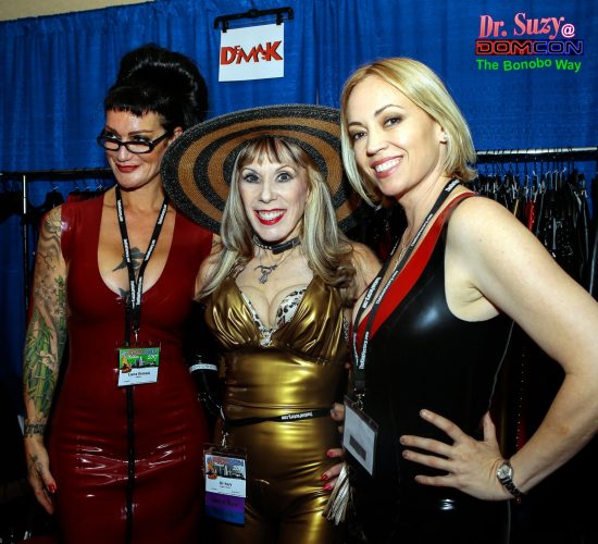 In My Demask Latex Catsuit at the Demask Booth with Louva & Mistress Isabella Sinclaire. Photo: B Natural