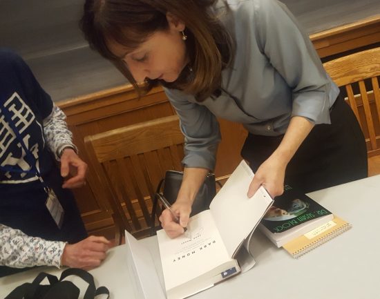 Jane Mayer signs her book "Dark Money" for a fan on top of her copy of "The Bonobo Way."