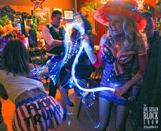 Spanking Phoenix's "Fuck Trump" behind with the "Rockets Red Glare" of Goddess Phoenix's lightning whip. Photo: Axel Carnigan