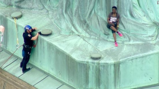 Therese Patricia Okoumou's Statue of Liberty climbing attire: Anti-Trump Tee & Hot Pink Sneaks.